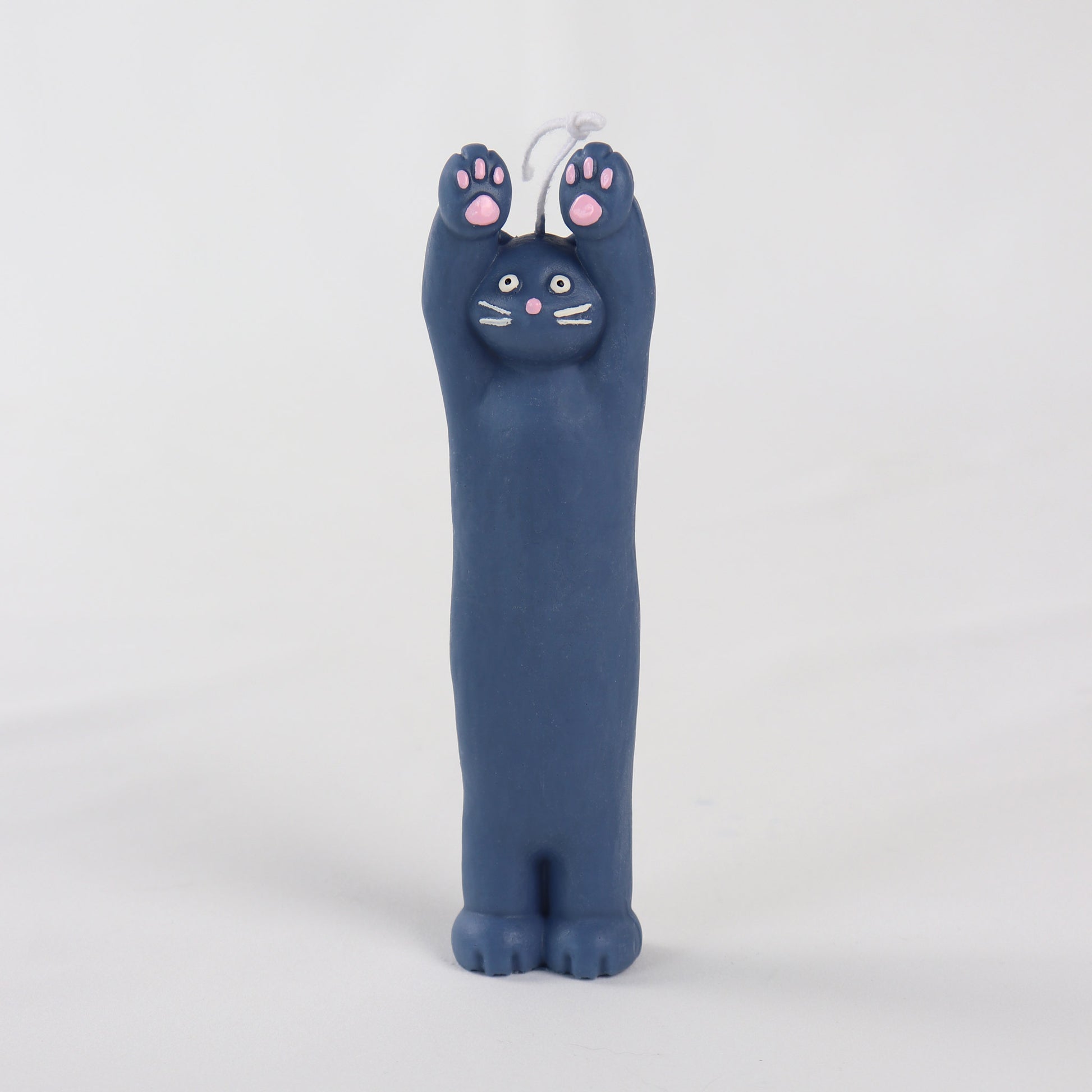 Navy candle in the shape of a cat standing with its hands up