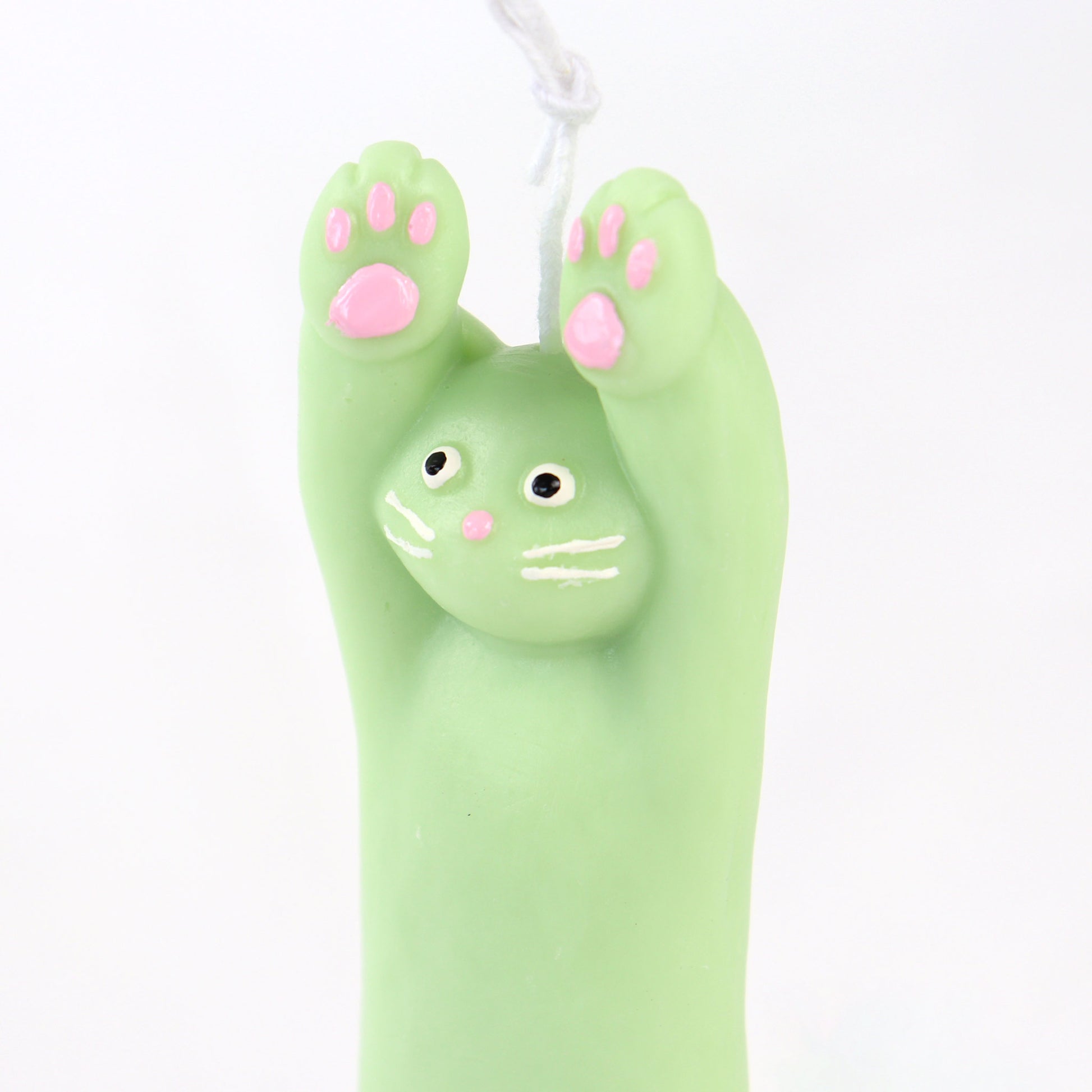 Green candle in the shape of a cat with its paws up
