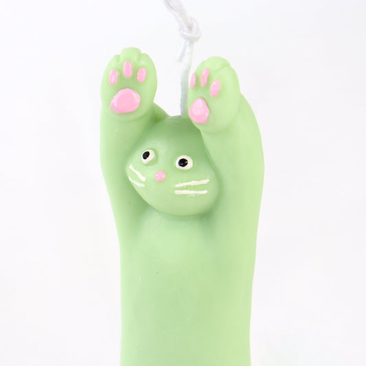 Green candle in the shape of a cat with its paws up