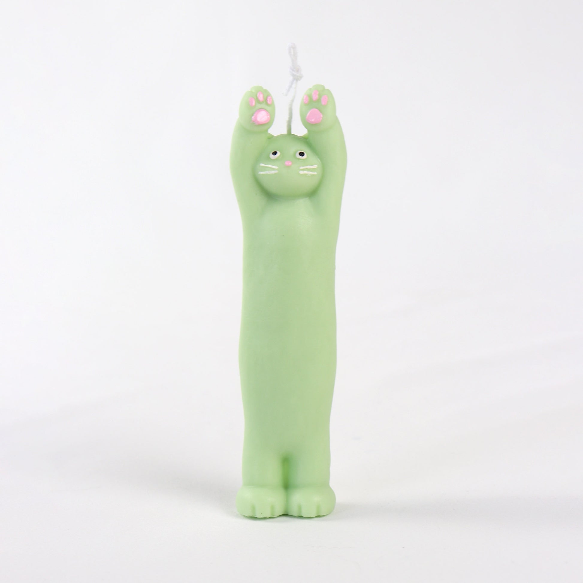 Green candle in the shape of a cat standing with its paws up