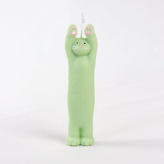 Green candle in the shape of a cat standing with its paws up