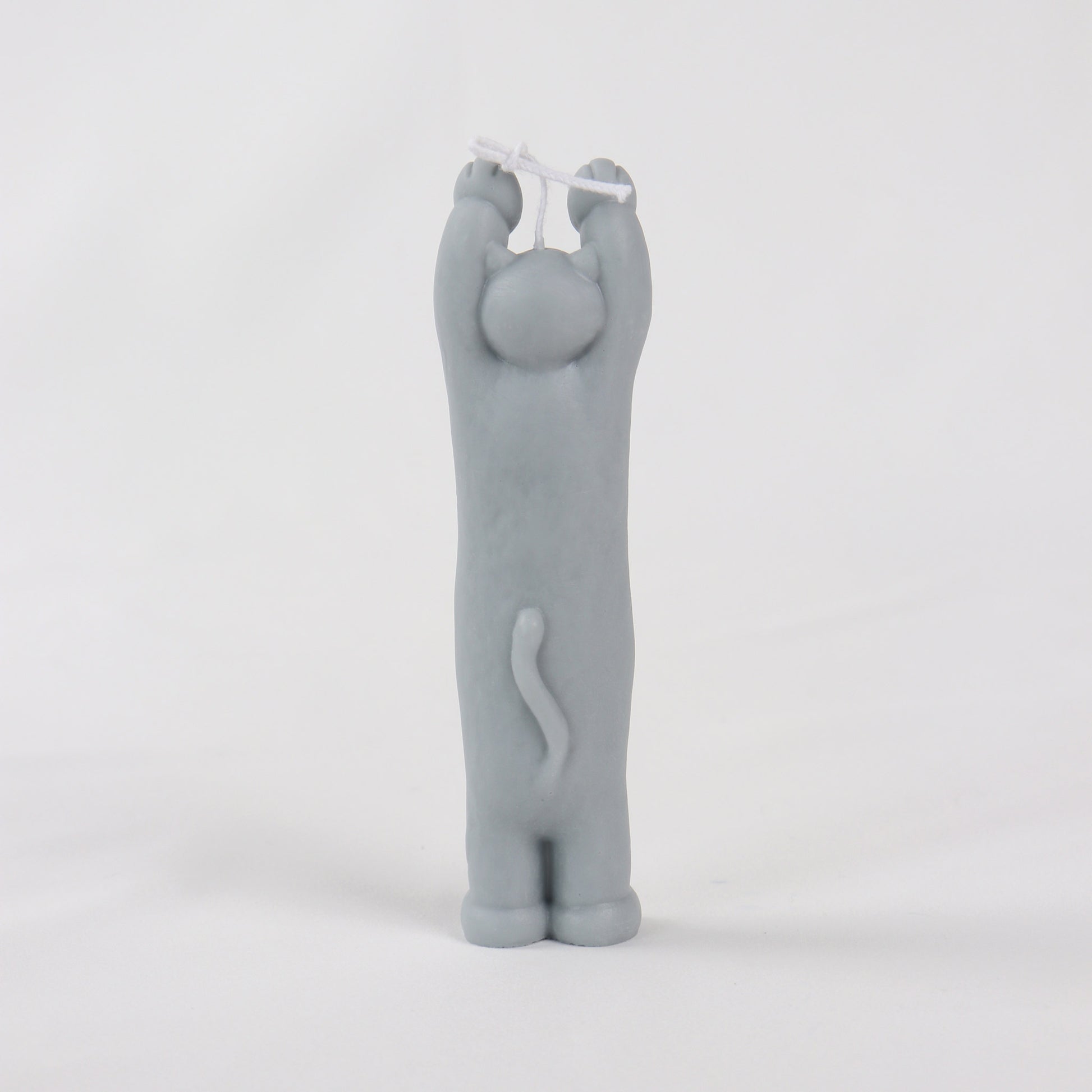 Back of a grey candle in the shape of a cat standing with its paws up