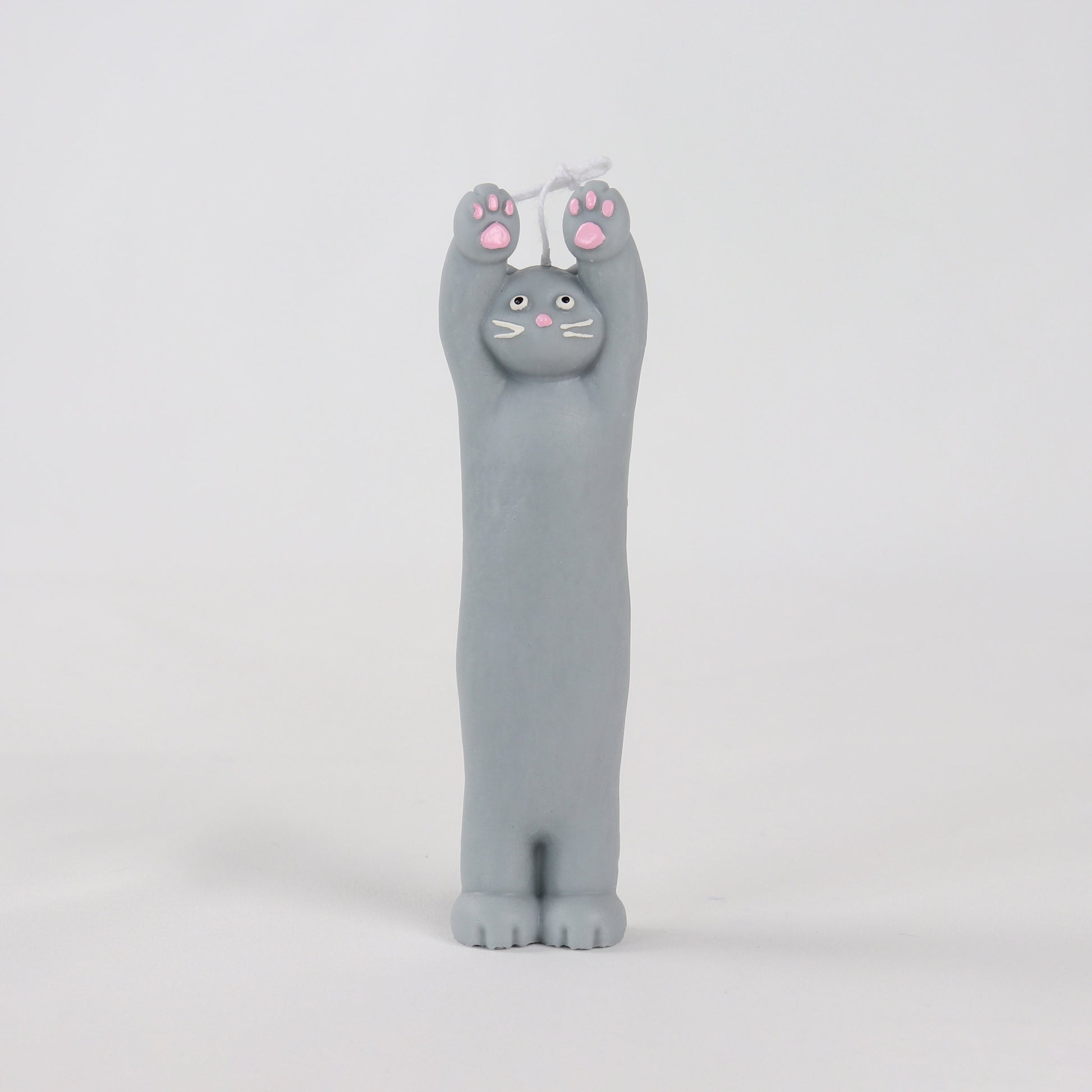 Grey candle in the shape of a cat standing with its paws up