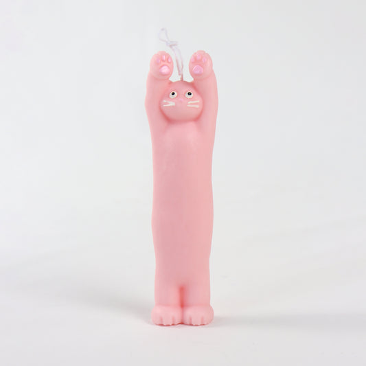 Pink candle in the shape of a cat standing with its paws up