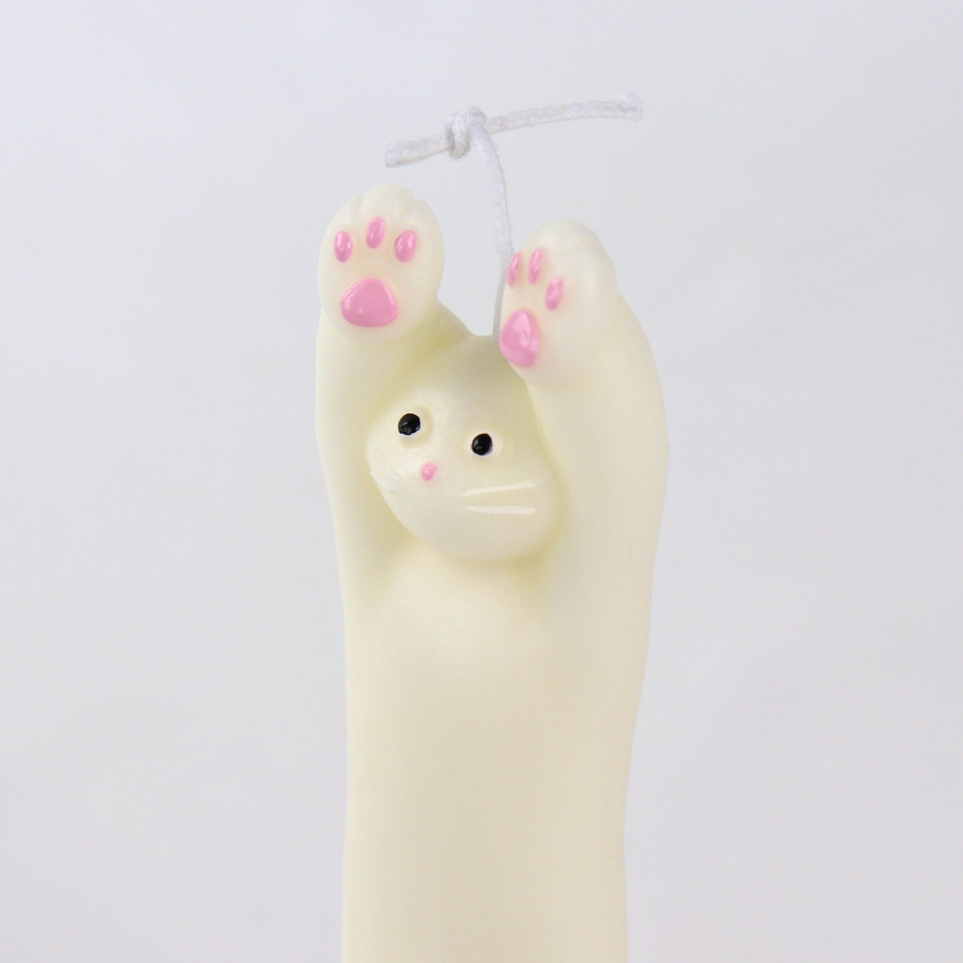 Candle in the shape of a white cat with its paws up