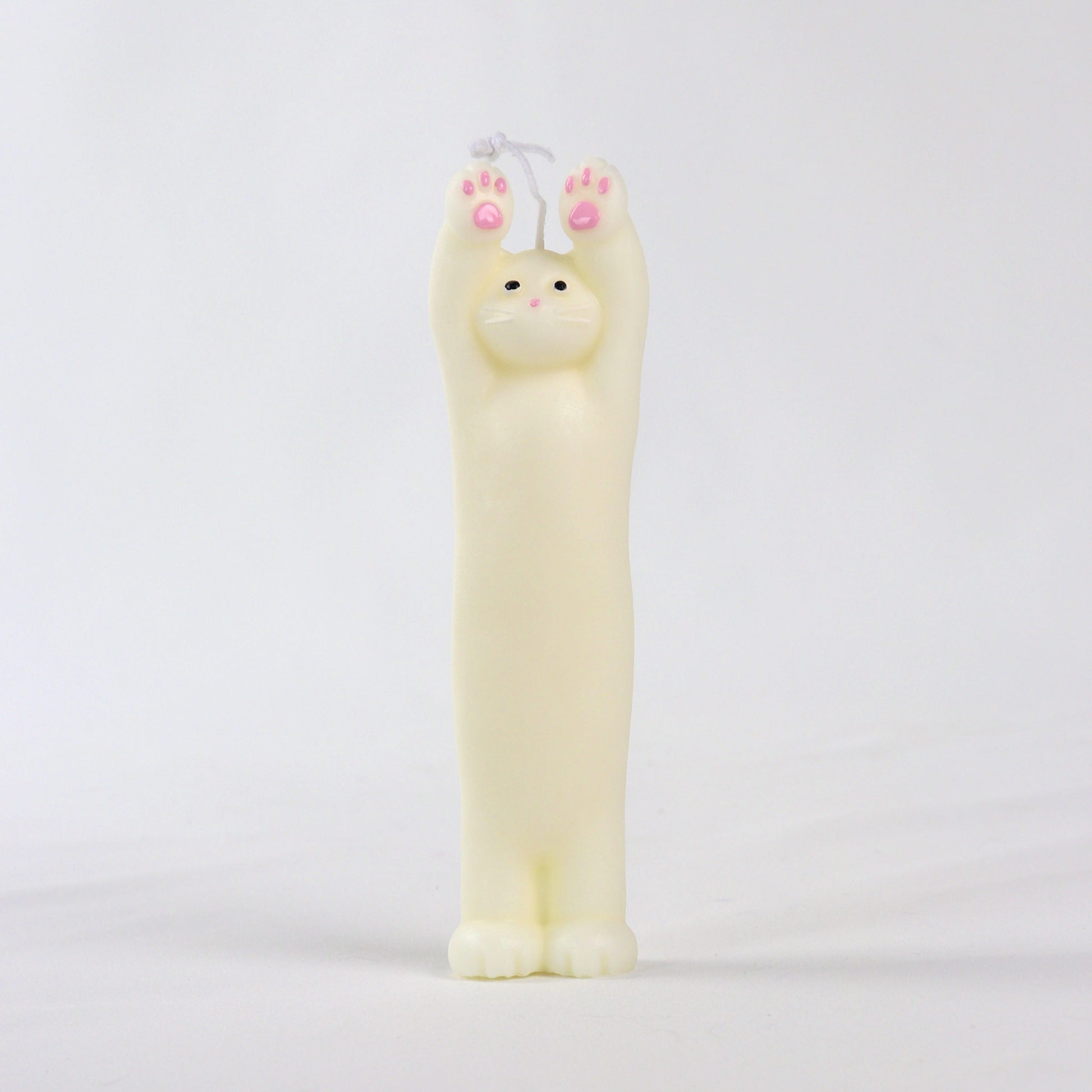 Candle in the shape of a white cat standing with paws up