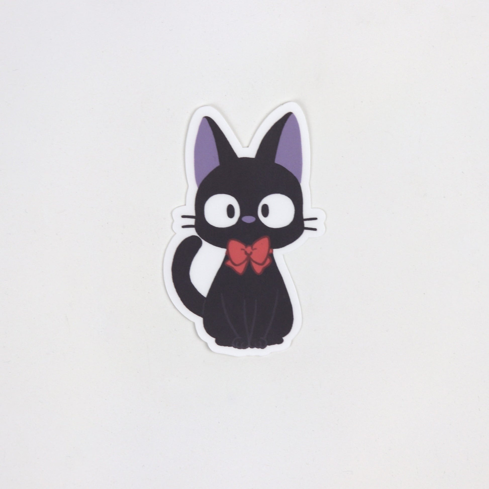 Cute fan art sticker of Jiji the black cat from Kiki’s Delivery Service, with wide eyes and upright ears. Matte, waterproof, approx. 5cm x 7cm.
