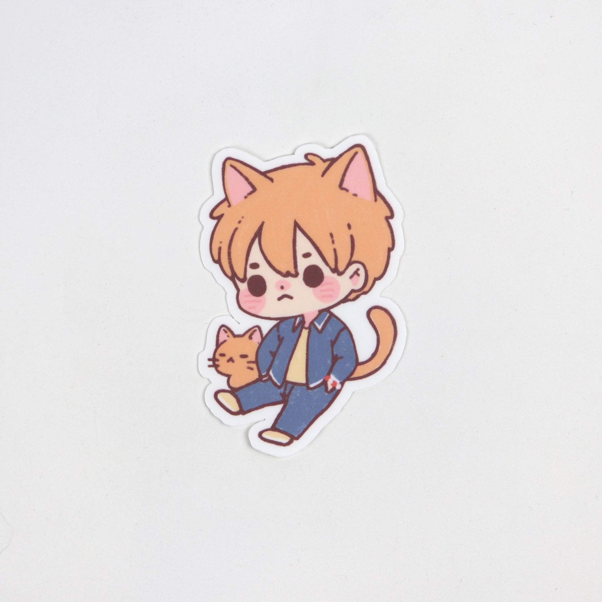 Matte waterproof sticker of Kyo Sohma from Fruits Basket as an orange cat with a red bracelet. Die cut, approx. 5cm x 7cm.