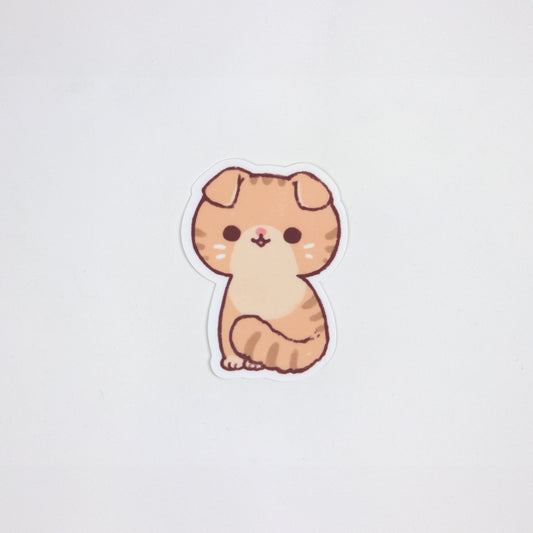 Die-cut matte sticker of a ginger Scottish Fold cat sitting, with folded ears and a round face. Waterproof, approx. 5cm x 7cm.