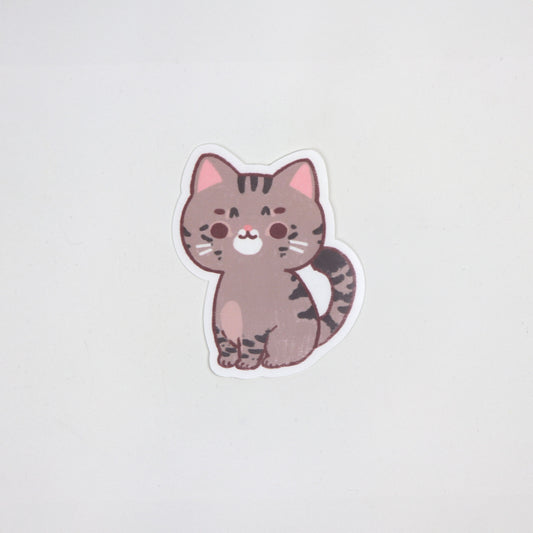 Matte die-cut waterproof sticker of a brown tabby cat with dark stripes and pink ears, approx. 5cm x 7cm.