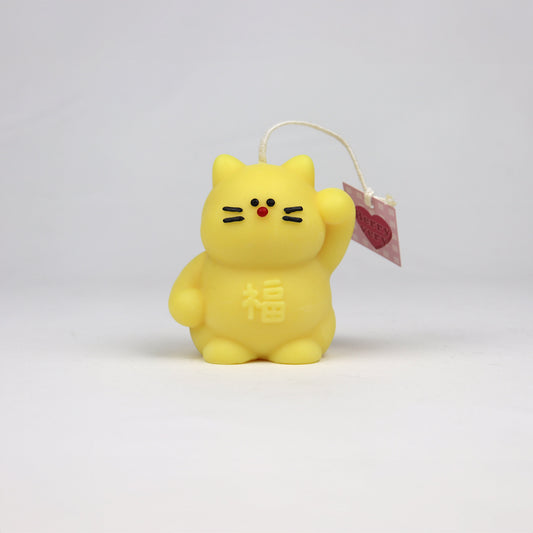 Yellow handmade lucky cat candle with cotton wick, soy-based and scented, made in Sydney.