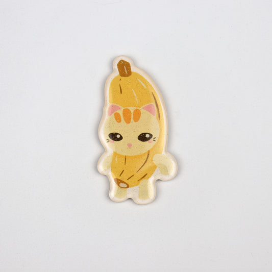 A yellow acrylic magnet of the banana cat meme.