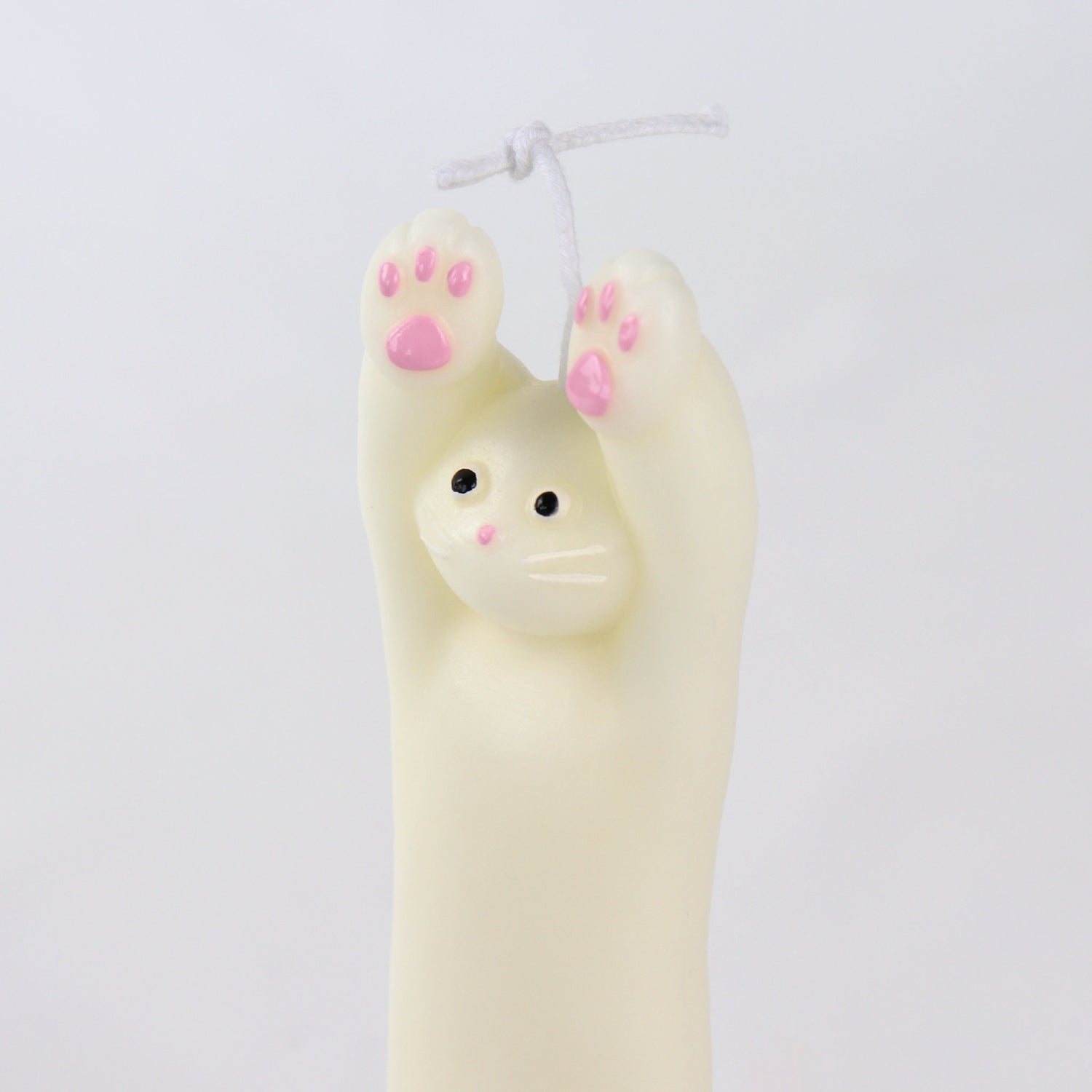Candle in the shape of a white cat with its paws up