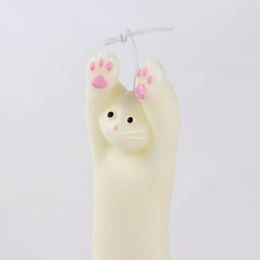 Candle in the shape of a white cat with its paws up
