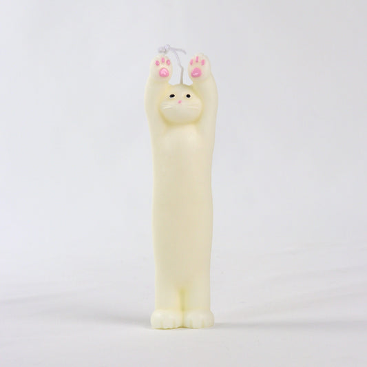 Candle in the shape of a white cat standing with paws up