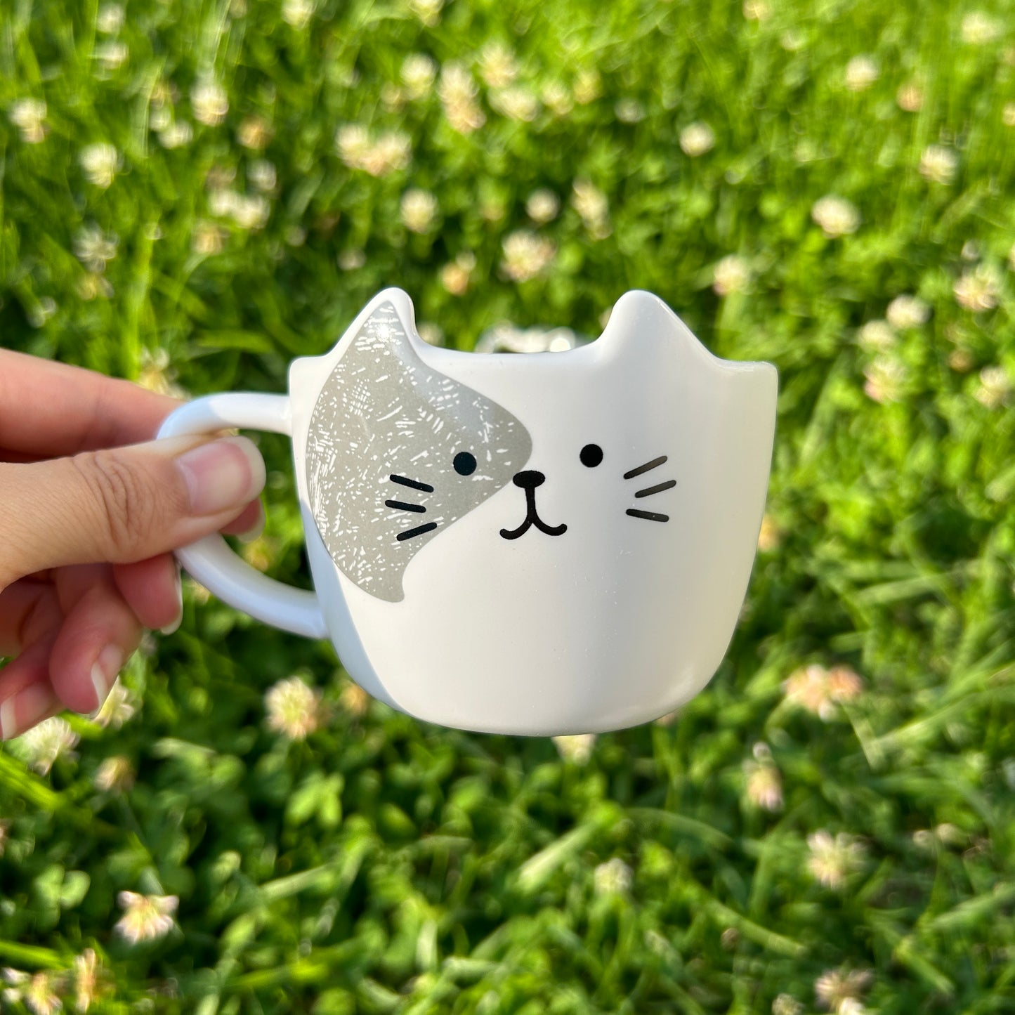 ceramic cat cup with grass background