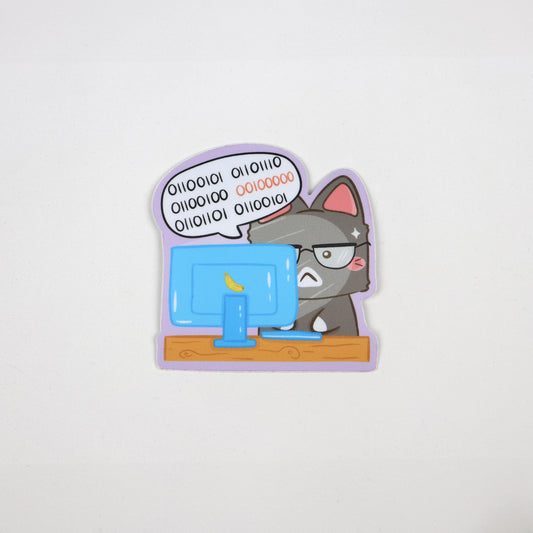 Vinyl sticker of a stressed grey cat with pink ears typing binary code on a blue computer at a desk. Waterproof, weatherproof, and die cut.