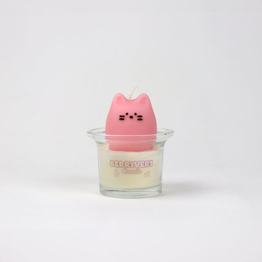 A pink, cat-shaped candle with a clear container, presumably wax, for a home fragrance product.