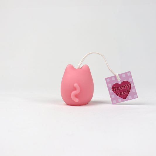 Back of a small pink soy wax pouch candle shaped like a cat with a squiggly tail, handmade in Brisbane.