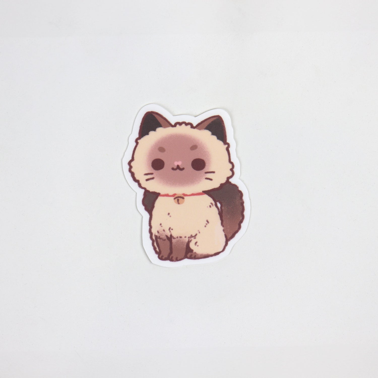 Sticker of a sitting ragdoll cat with round eyes and soft fur details. Matte, waterproof, die cut, approx. 5cm x 7cm.