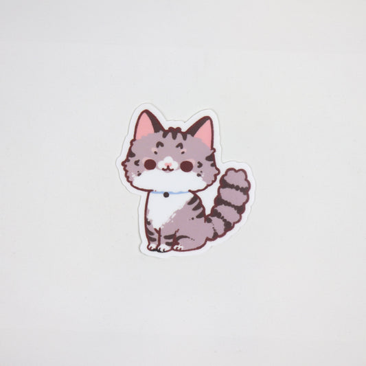 Matte waterproof die-cut sticker of a fluffy tabby cat with grey stripes, blue collar, and pink ears, approx. 5cm x 7cm.