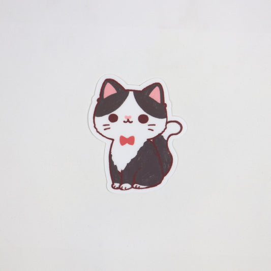Matte die-cut waterproof sticker of a tuxedo cat wearing a red bow tie, approx. 5cm x 7cm.