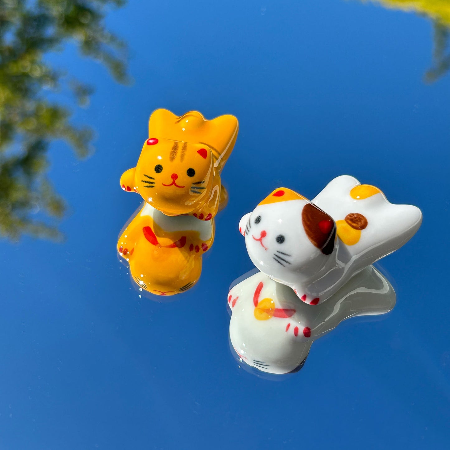 two cute cat chopstick holders on mirror