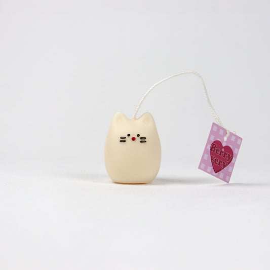 Small white cat-shaped pouch candle with red nose and whiskers, handmade in Brisbane from soy wax.